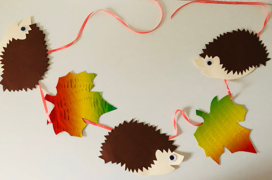 Herbst: Girlande mit bunten Blättern und Igeln